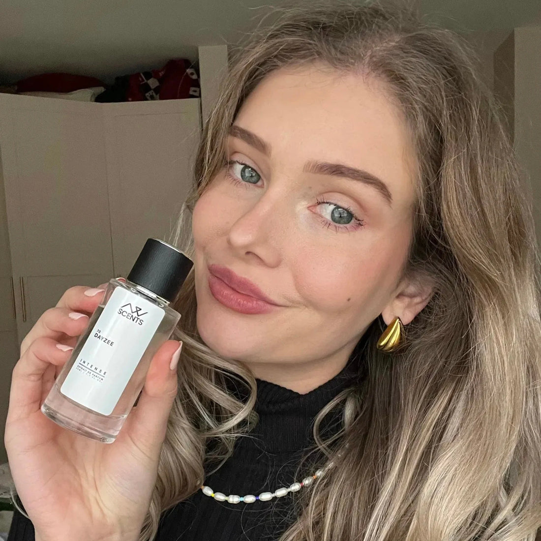 Female customer holding an AW Scents perfume bottle